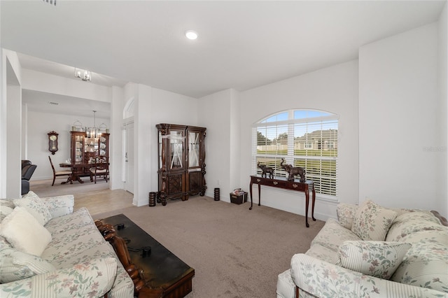 living room with light carpet and an inviting chandelier