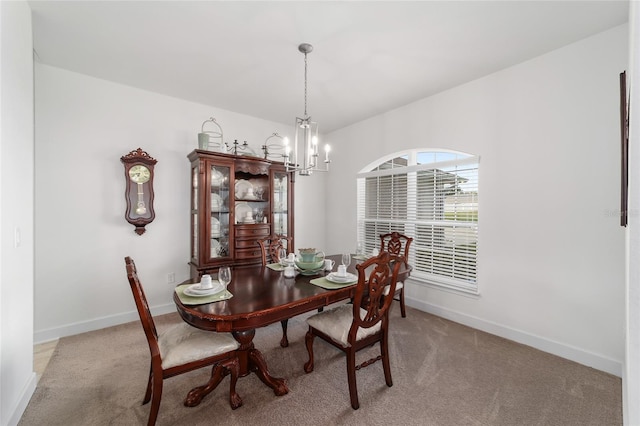 dining space featuring an inviting chandelier and light carpet