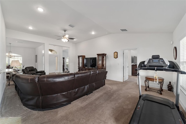 living room featuring plenty of natural light, dark carpet, ceiling fan with notable chandelier, and vaulted ceiling