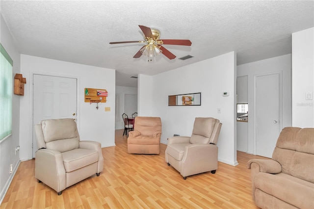 interior space with a textured ceiling, light hardwood / wood-style floors, and ceiling fan