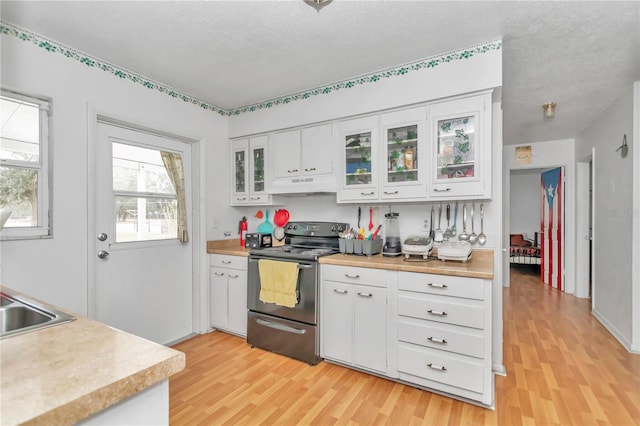 kitchen featuring white cabinets, a textured ceiling, black electric range, and light wood-type flooring