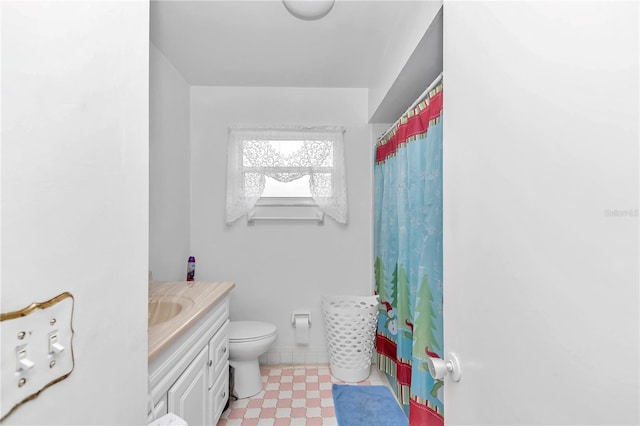 bathroom with tile floors, toilet, and vanity