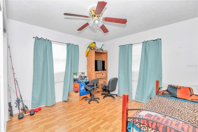 bedroom featuring a textured ceiling, ceiling fan, and light wood-type flooring