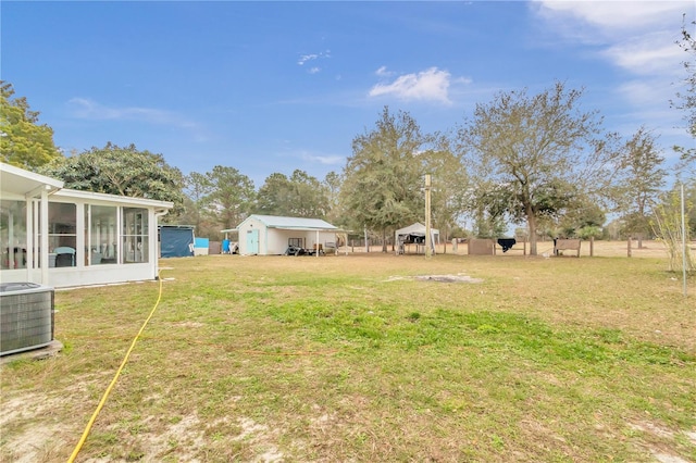 view of yard with a sunroom and central air condition unit