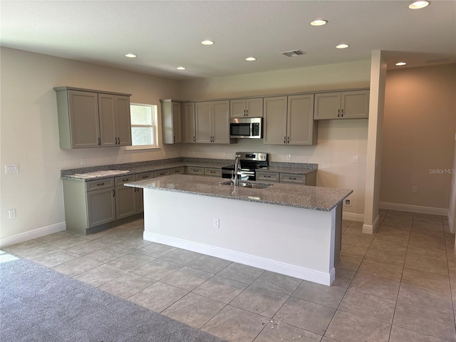 kitchen featuring appliances with stainless steel finishes, gray cabinetry, and a kitchen island with sink