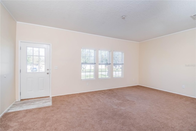 entryway with light colored carpet, a textured ceiling, and ornamental molding