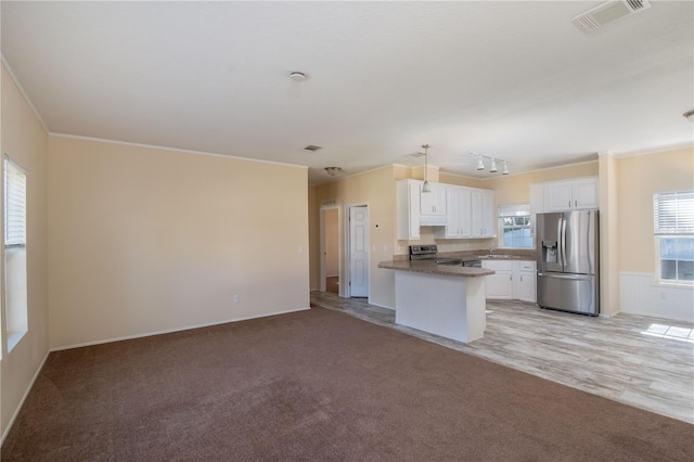 kitchen with light colored carpet, white cabinetry, kitchen peninsula, and appliances with stainless steel finishes