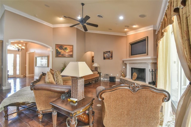 living room with ornamental molding, ceiling fan with notable chandelier, and dark hardwood / wood-style floors