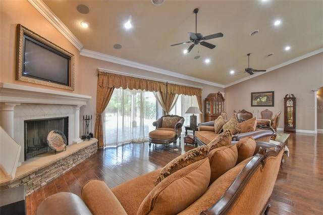 living room featuring vaulted ceiling, a stone fireplace, dark wood-type flooring, ornamental molding, and ceiling fan