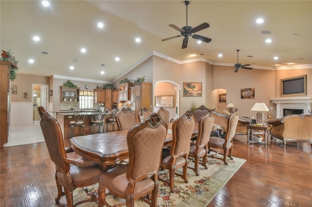 dining space with lofted ceiling, hardwood / wood-style floors, ceiling fan, and crown molding