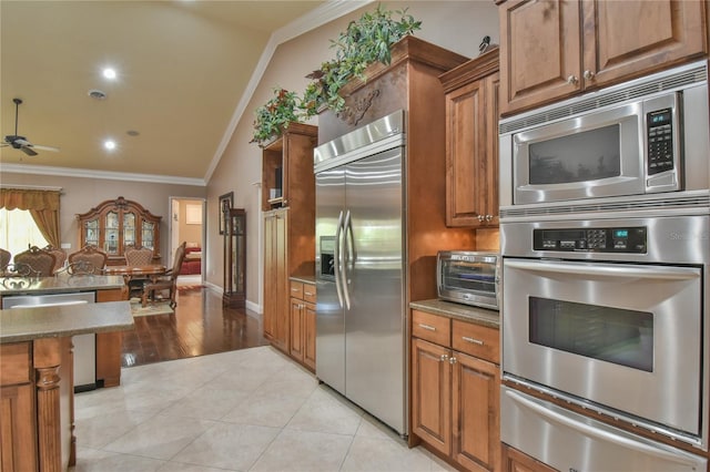 kitchen featuring ornamental molding, built in appliances, ceiling fan, vaulted ceiling, and light hardwood / wood-style floors