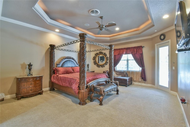 carpeted bedroom with ceiling fan, a raised ceiling, and ornamental molding