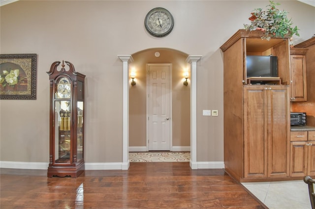 entryway featuring hardwood / wood-style floors and decorative columns