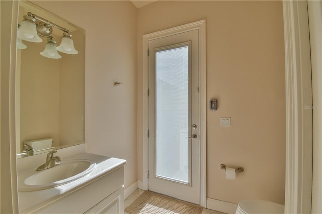 bathroom with tile patterned flooring, toilet, a wealth of natural light, and vanity