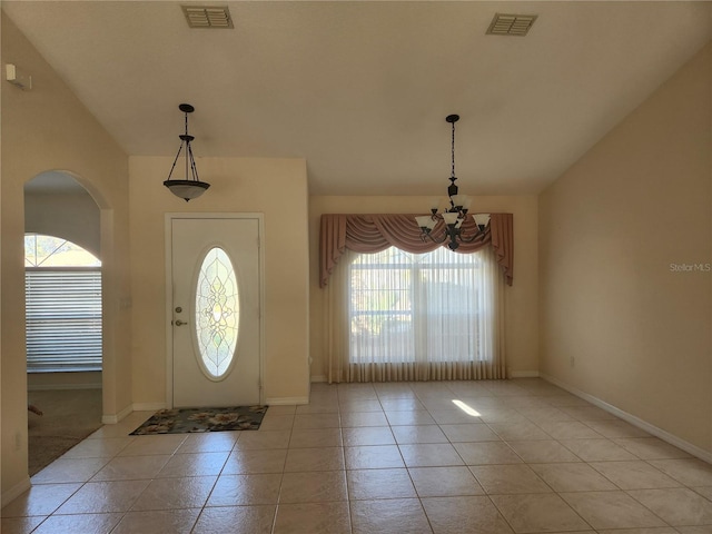 tiled entrance foyer featuring a chandelier and a wealth of natural light