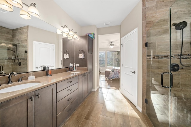 bathroom featuring an enclosed shower, double sink, oversized vanity, and ceiling fan