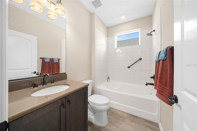 full bathroom with tiled shower / bath, toilet, vanity with extensive cabinet space, and hardwood / wood-style flooring