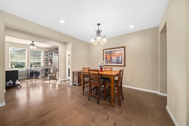 dining area with dark wood-type flooring and ceiling fan with notable chandelier