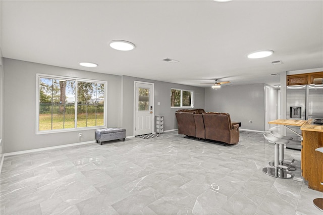 interior space with ceiling fan and light tile flooring