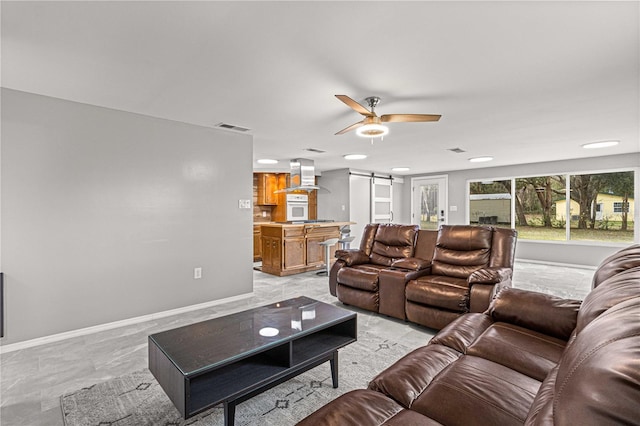 living room featuring a barn door, ceiling fan, and light tile floors