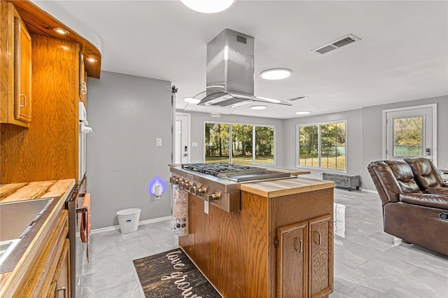 kitchen with light tile floors, oven, dishwasher, and island range hood