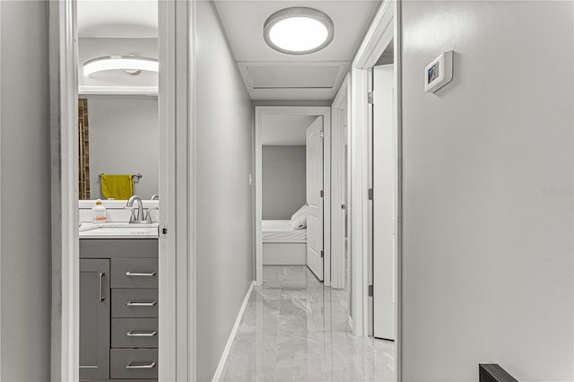 corridor featuring light tile floors and sink