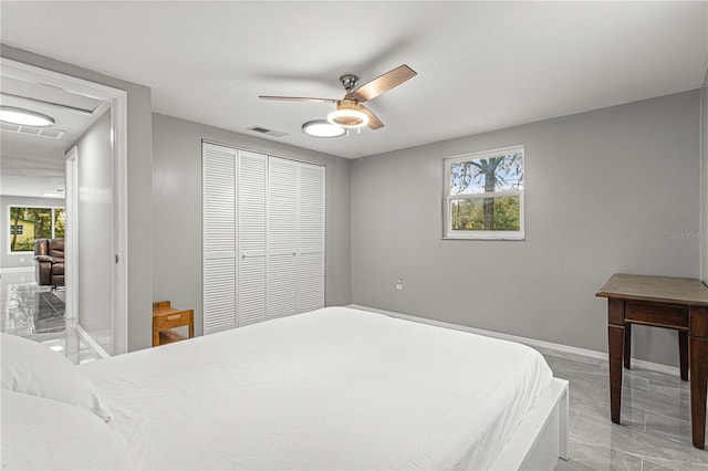 bedroom with light tile floors, a closet, and ceiling fan