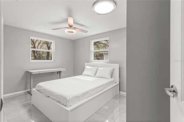 bedroom featuring light tile flooring, ceiling fan, and multiple windows