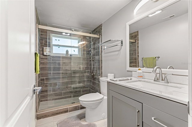 bathroom featuring an enclosed shower, toilet, vanity, and tile flooring