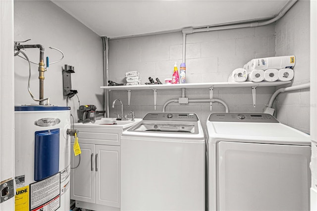 laundry area featuring washing machine and clothes dryer, cabinets, electric water heater, and sink