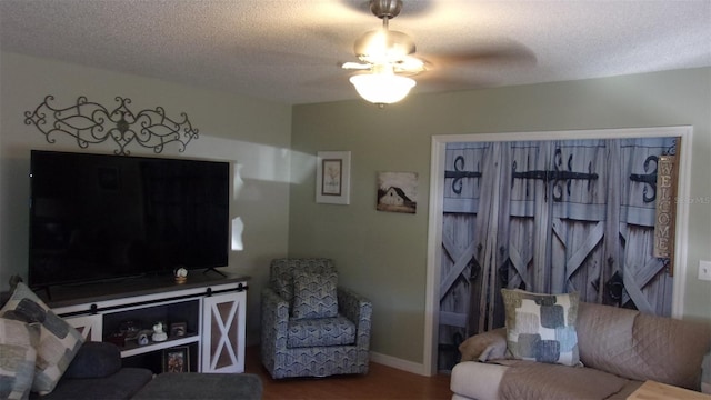 living room with a textured ceiling, ceiling fan, and dark hardwood / wood-style flooring