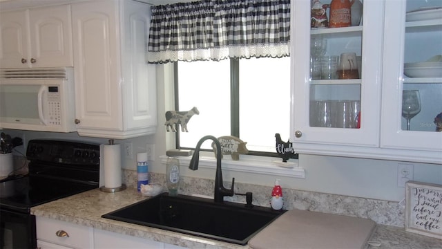 kitchen featuring white cabinetry, black range with electric cooktop, and sink