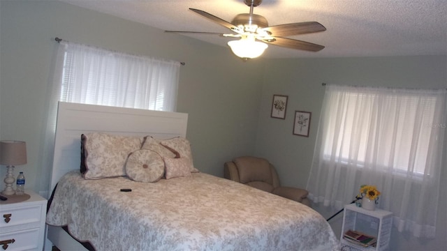 bedroom with ceiling fan and a textured ceiling