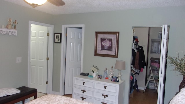 bedroom with a closet, hardwood / wood-style floors, a textured ceiling, and ceiling fan