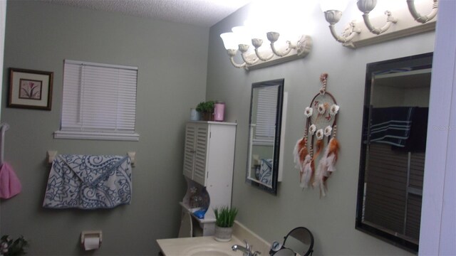 bathroom featuring a textured ceiling, a chandelier, and sink