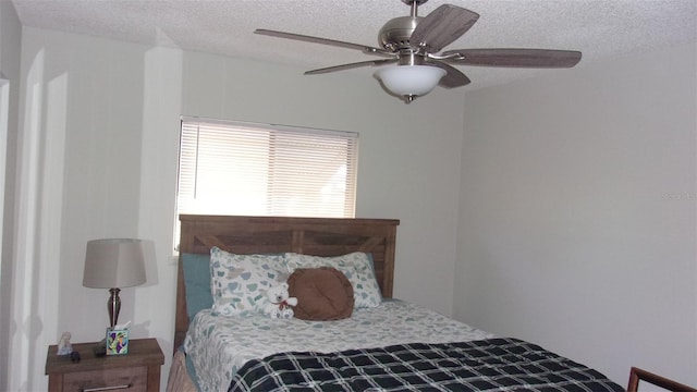 bedroom featuring ceiling fan and a textured ceiling