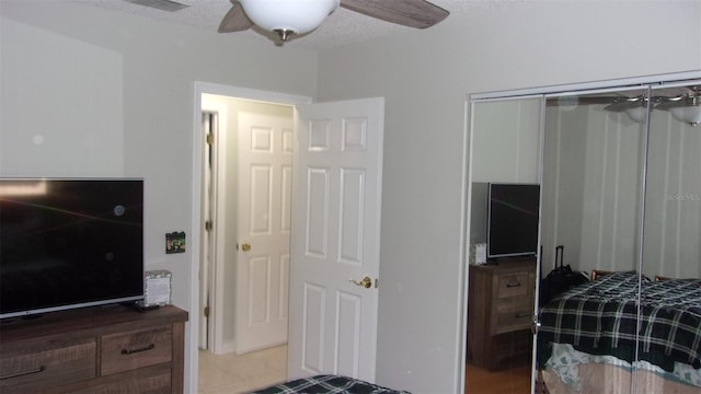 tiled bedroom featuring a closet, a textured ceiling, and ceiling fan