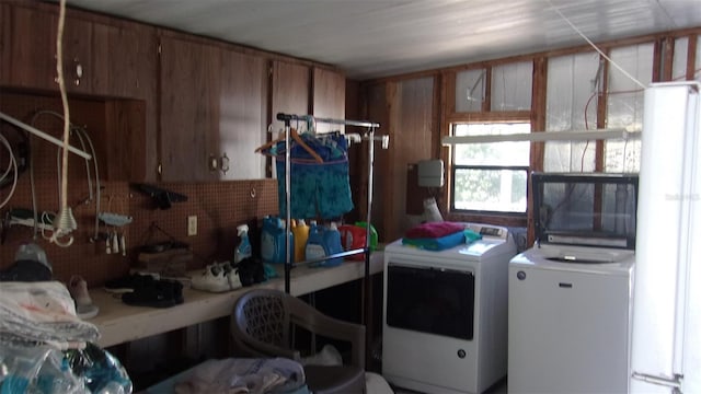 washroom with washer and dryer and cabinets