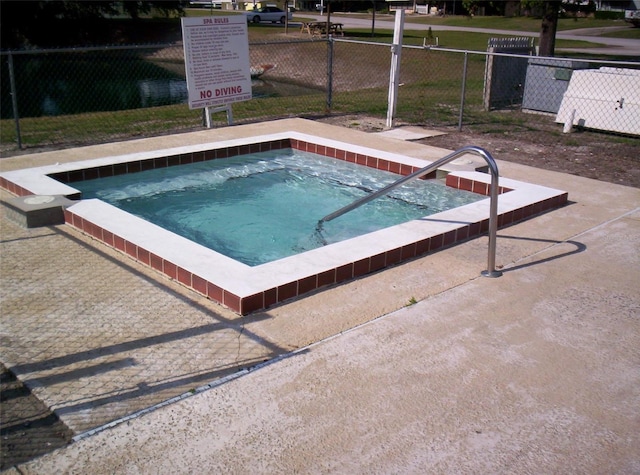 view of pool with a hot tub