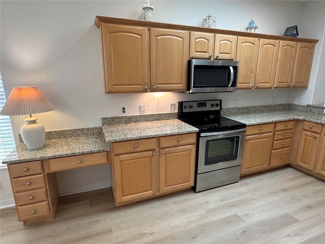 kitchen with stainless steel appliances, light hardwood / wood-style floors, and light stone counters