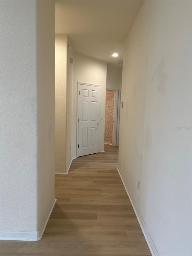 hallway with light hardwood / wood-style floors