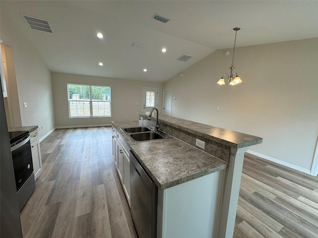 kitchen featuring pendant lighting, sink, white cabinets, stainless steel appliances, and a center island with sink