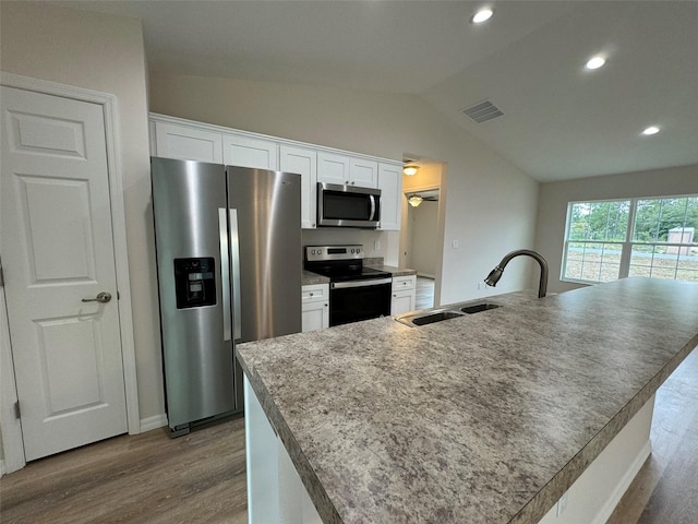 kitchen with stainless steel appliances, sink, a center island with sink, and white cabinets