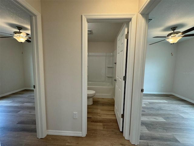 bathroom featuring wood-type flooring, ceiling fan, a textured ceiling, and toilet