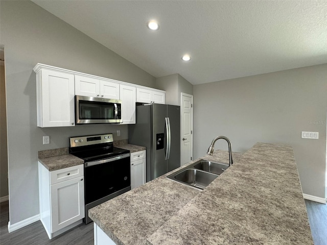 kitchen with dark hardwood / wood-style floors, sink, white cabinets, a kitchen island with sink, and stainless steel appliances