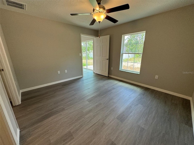 spare room featuring ceiling fan, dark hardwood / wood-style floors, and a textured ceiling