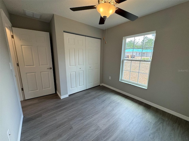 unfurnished bedroom featuring a closet, dark hardwood / wood-style floors, and ceiling fan