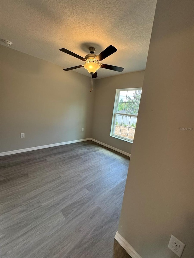 unfurnished room with dark wood-type flooring, ceiling fan, and a textured ceiling