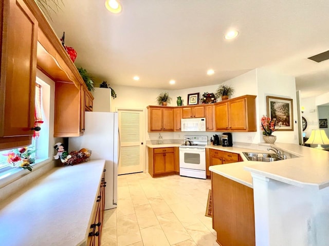 kitchen with white appliances, kitchen peninsula, and sink