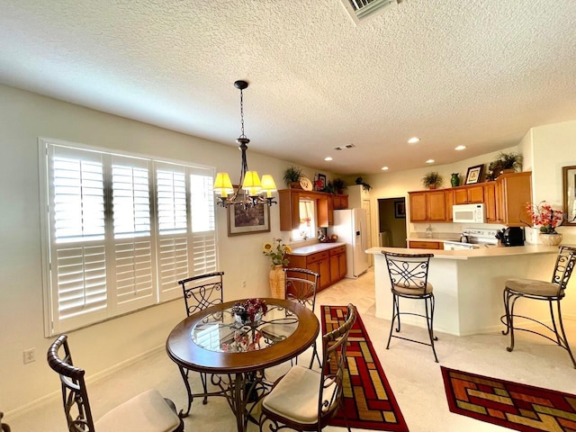 dining room with light colored carpet, a textured ceiling, and an inviting chandelier